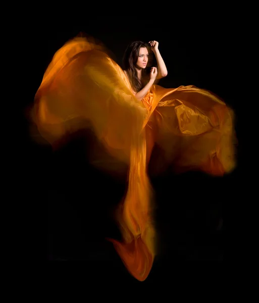 Девушка в оранжевом платье из летучей ткани — стоковое фото