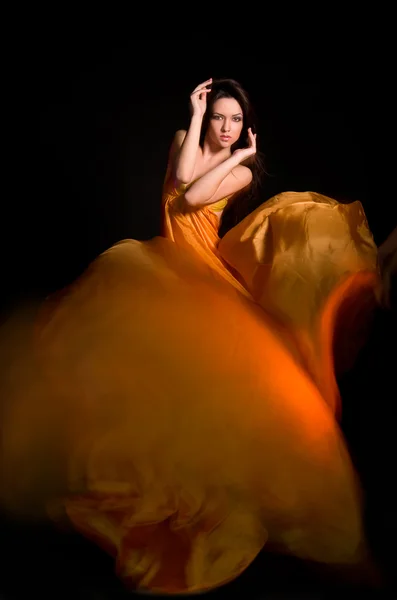Dívka v oranžové šaty od létání tkanina — Stock fotografie
