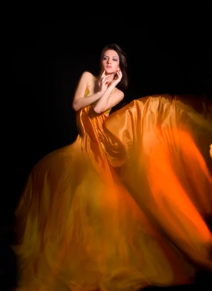 Девушка в оранжевом платье из летучей ткани — стоковое фото