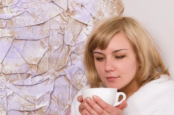 Blonďatá holka pije čaj z bílého hrnečku — Stock fotografie