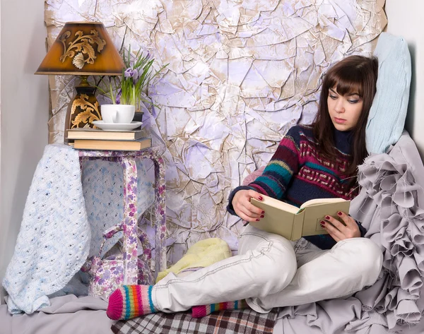 Flicka i vinterkläder läser en bok — Stockfoto