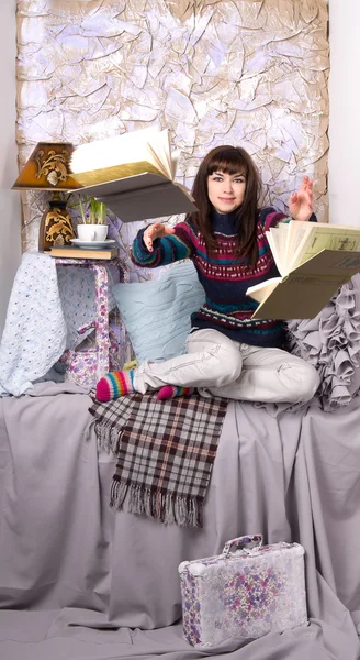 Mädchen in Winterkleidung wirft Bücher — Stockfoto