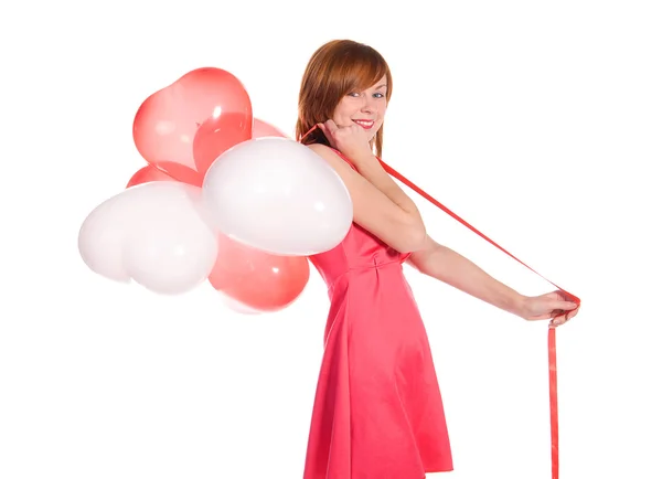 Roodharige meisje in een roze jurk met ballonnen — Stockfoto