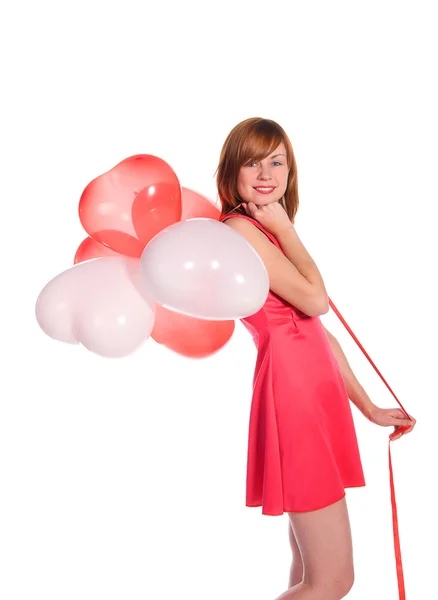 Roodharige meisje in een roze jurk met ballonnen — Stockfoto