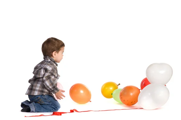 Маленький мальчик играет с воздушными шарами — стоковое фото