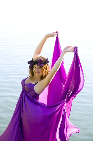 Girl with curly hair flying in the purple dress — Stock Photo, Image
