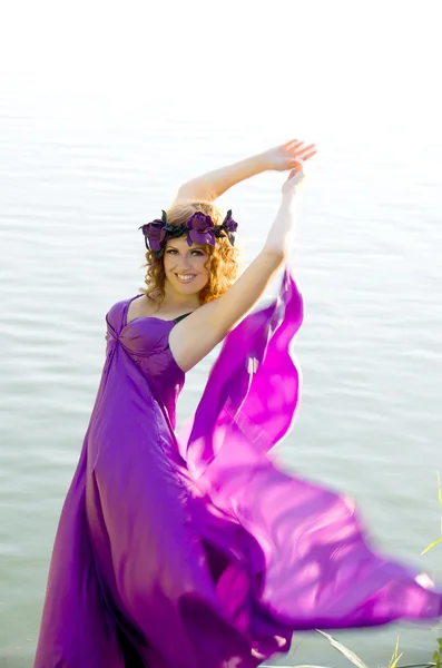 Menina com cabelo encaracolado voando no vestido roxo — Fotografia de Stock