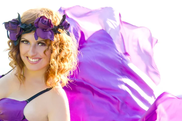 Fille aux cheveux bouclés volant dans la robe violette — Photo