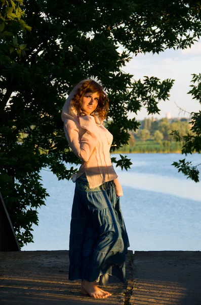 Девушка, хиппи, на фоне заходящего солнца, реки и — стоковое фото