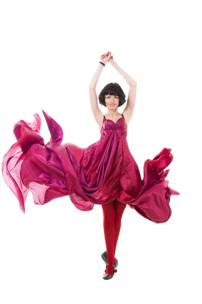 Meisje in een rode jurk vliegen in een sprong — Stockfoto