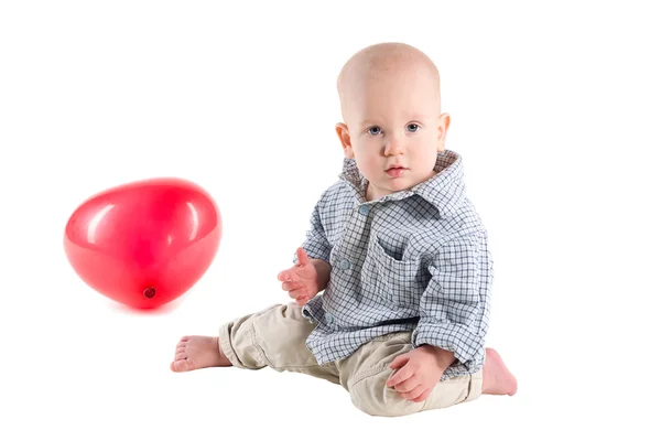 Παιδί αγόρι είναι σε ένα καρό πουκάμισο, ένα κόκκινο μπαλόνι με τη μορφή της — Φωτογραφία Αρχείου