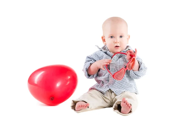 Παιδί αγόρι είναι σε ένα καρό πουκάμισο, ένα κόκκινο μπαλόνι με τη μορφή της — Φωτογραφία Αρχείου