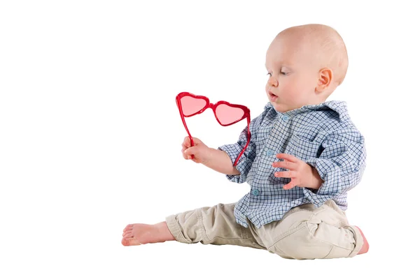 Jongenskind is in een plaid shirt en een rood hart-vormige glasplaten — Stockfoto
