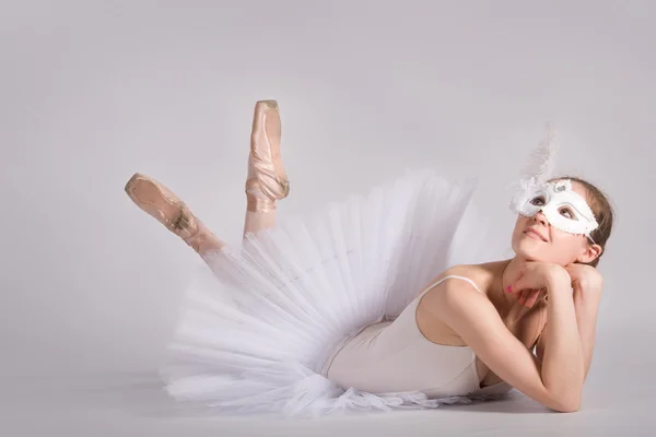 Balletdanser in een witte tutu en een carnaval masker — Stockfoto