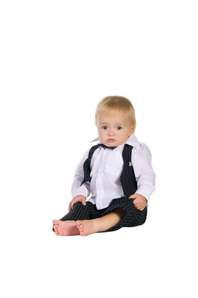 Menino senta-se em uma camisa, colete e calças — Fotografia de Stock