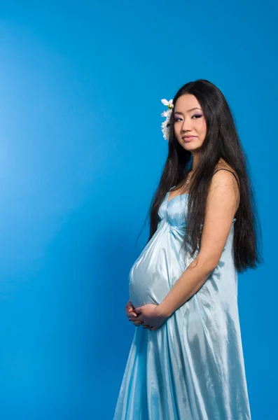 Беременная азиатка в шелковом платье — стоковое фото