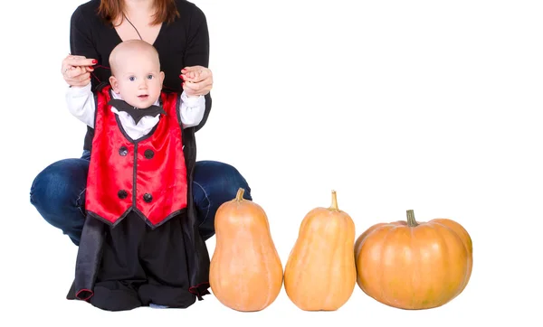 Baby boy in black halloween cloak playing with pumpkin — Stock Photo, Image