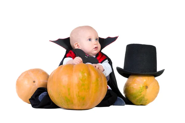 Baby boy in black halloween cloak playing with pumpkin — Stock Photo, Image