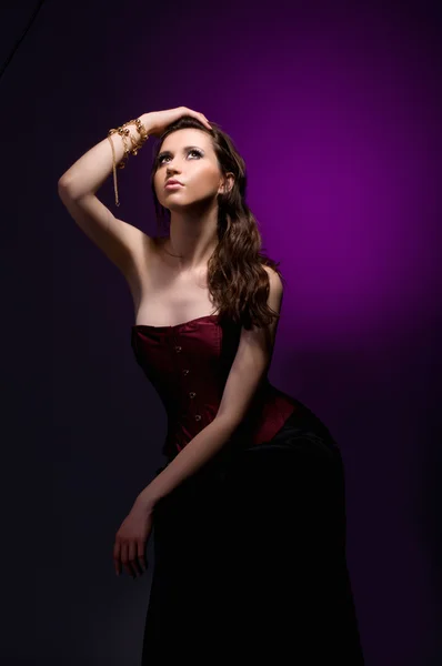 Sexy brunette meisje met donkerrood korset — Stockfoto