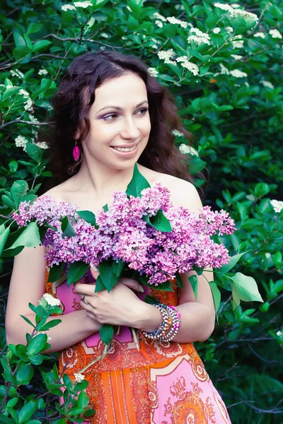 Kvinna med lila blommor — Stockfoto