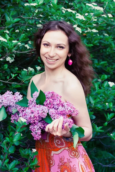 Vrouw met lila bloemen — Stockfoto