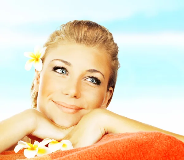 Vrouw op spa massagebed op het strand — Stockfoto