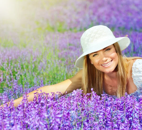 Schönes glückliches Weibchen legt sich auf Lavendelfeld — Stockfoto