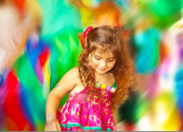 Urocza mała dziewczynka tańczy na rozmycie kolorów tła — Zdjęcie stockowe