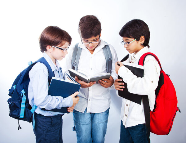 Трое милых школьников читают книги
