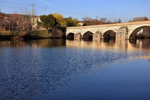 Římský most na řece Arlanza ve městě Puentedura. Castilla - — Stock fotografie