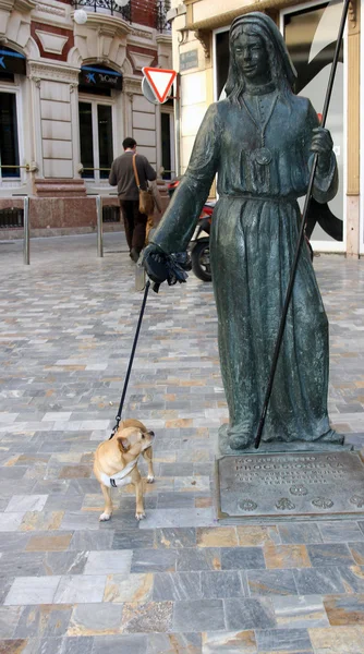 Oude sculptuur van een vrouw met een echte hond — Stockfoto