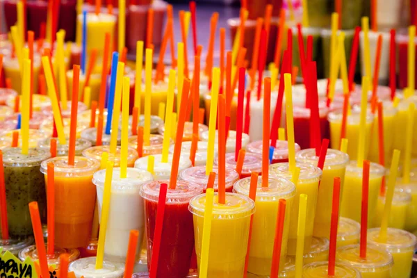 Copos de suco de frutas frescas naturais coloridos com palha — Fotografia de Stock