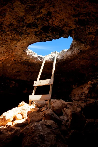 Barbaria cape cave hole with rustic ladder on wood — Stock Photo, Image