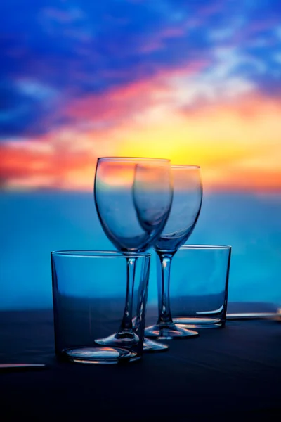 Чашки и хрустальные бокалы на морском закате — стоковое фото