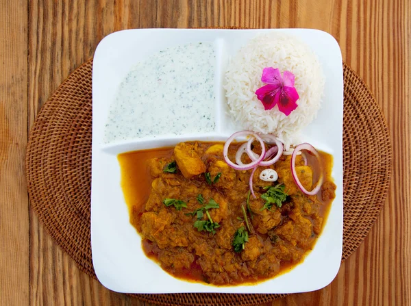 Curry y arroz sobre mesa de madera con flor rosa — Foto de Stock