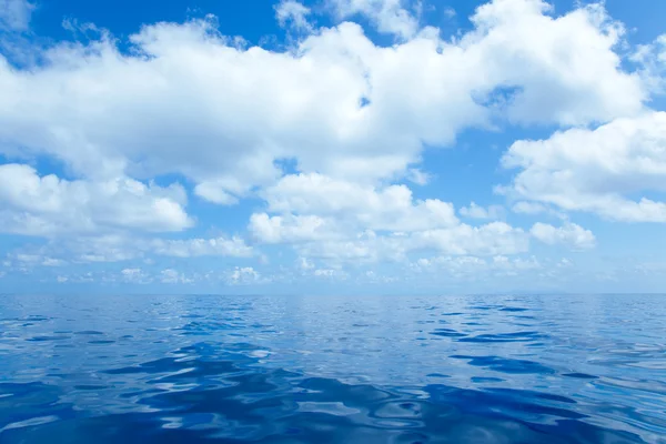 Blauwe kalme zeewater met wolken spiegelend oppervlak — Stockfoto