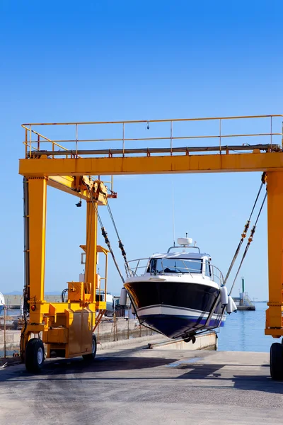 Crane travelift sollevando una barca nel giorno del cielo blu — Foto Stock
