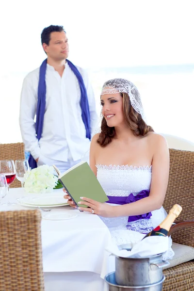 Пара в день свадьбы женщина читает книгу о банкете — стоковое фото