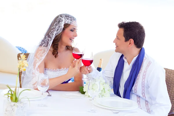 Casal no dia do casamento torcendo com vinho tinto — Fotografia de Stock