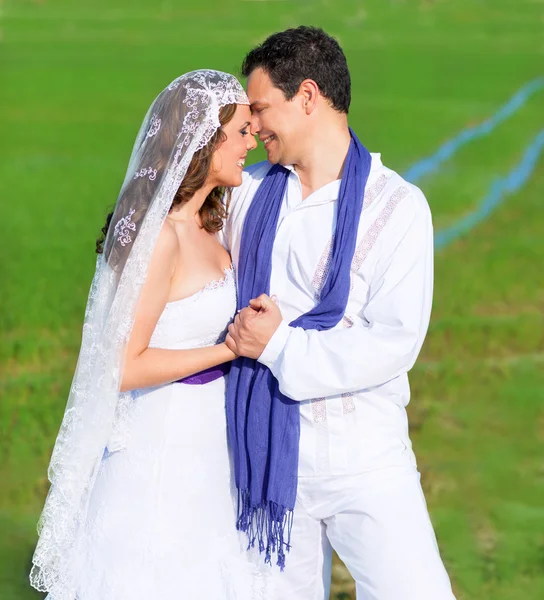 Couple in wedding day hug in green meadow — Stock Photo, Image