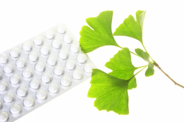 Leaves of the ginkgo tree and coated tablets — Stock Photo, Image
