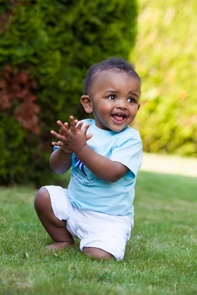 Pequeno menino afro-americano brincando na grama — Fotografia de Stock