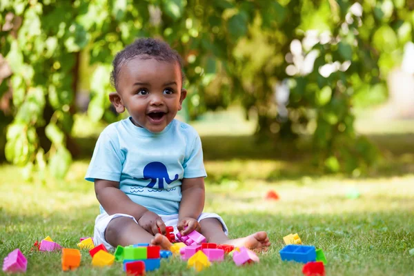 Malý Američan Afričana chlapeček hraje v trávě — Stock fotografie