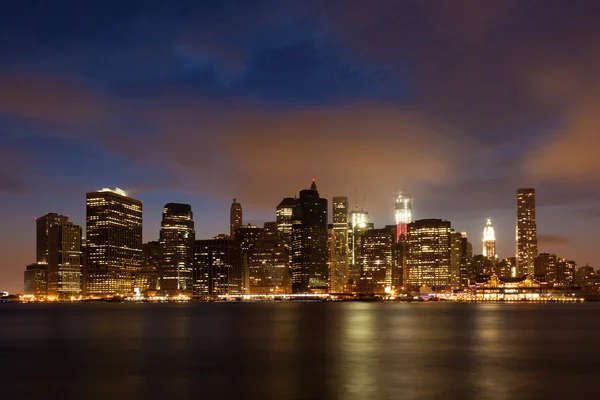 De skyline van Manhattan door nacht van brooklyn bridge park — Stockfoto