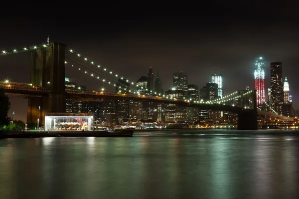 De skyline van Manhattan door nacht van brooklyn bridge park — Stockfoto