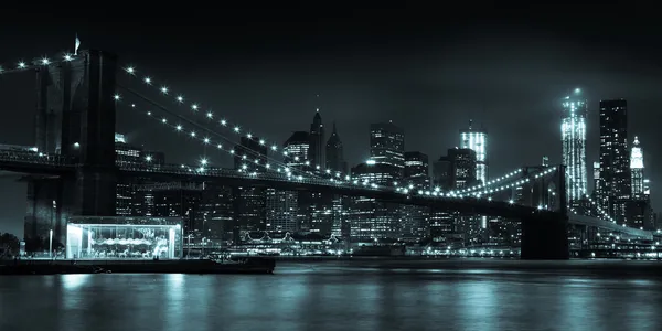 Linha do horizonte de Manhattan à noite a partir do Brooklyn Bridge Park Imagens De Bancos De Imagens