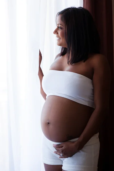 Mladá těhotná indiánka dotýká její bříško — Stock fotografie