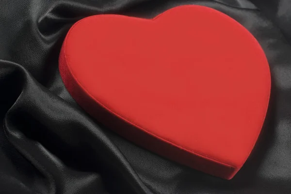 Rød hjerte på silkeagtig bølget stof - Stock-foto