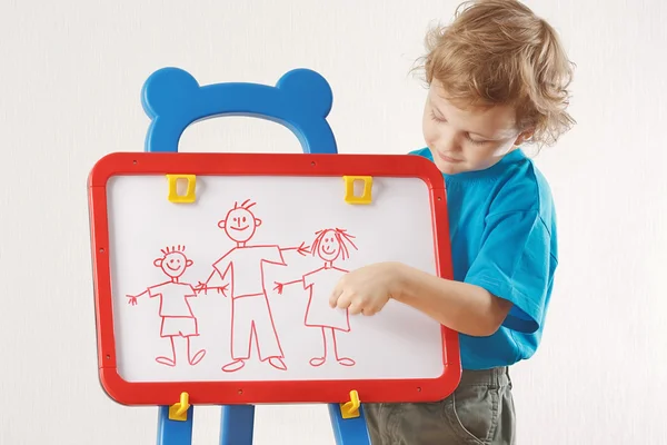 Little cute boy shows his family painted on whiteboard