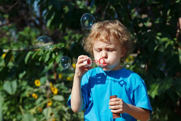 Young boy blowing a bubbles on a sunny day — Stock Photo © borusikk ...